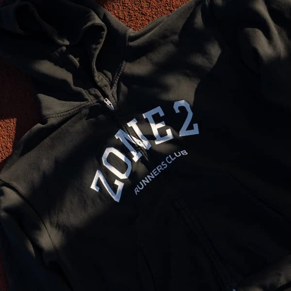 The Zone 2 hoodie laid on a red track in low sun